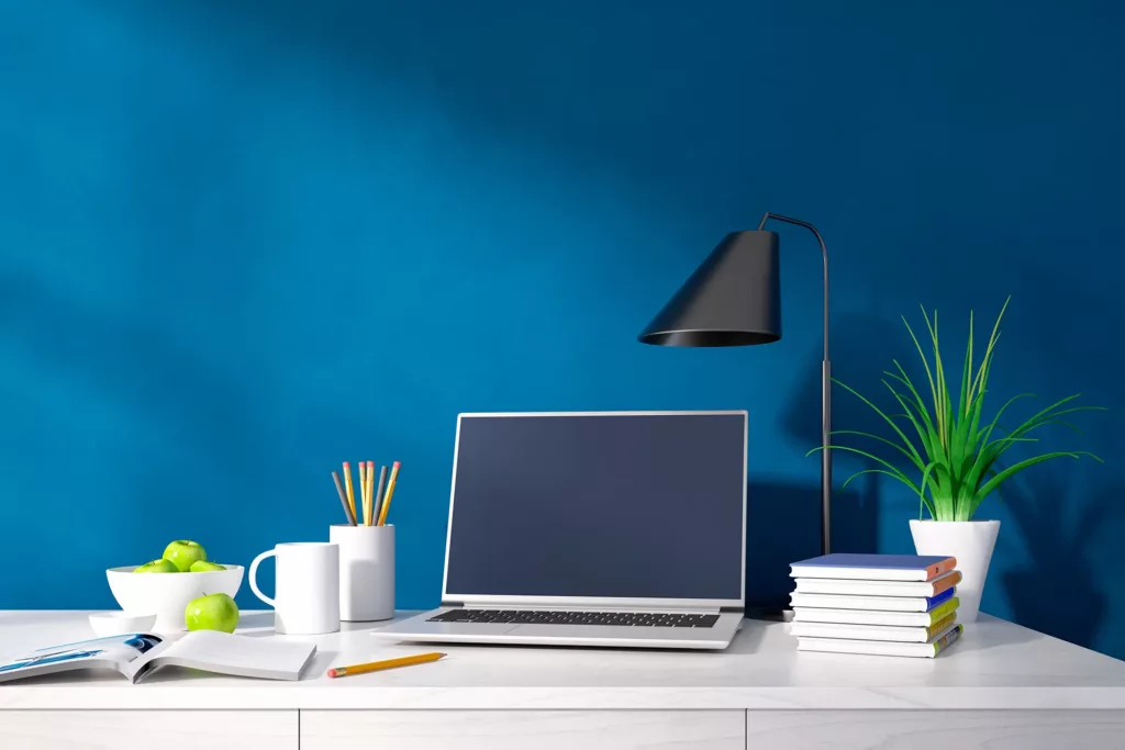 #600239227 – Interior of a modern home office with laptop against a blue wall with copy space: © peterschreiber.media / stock.adobe.com